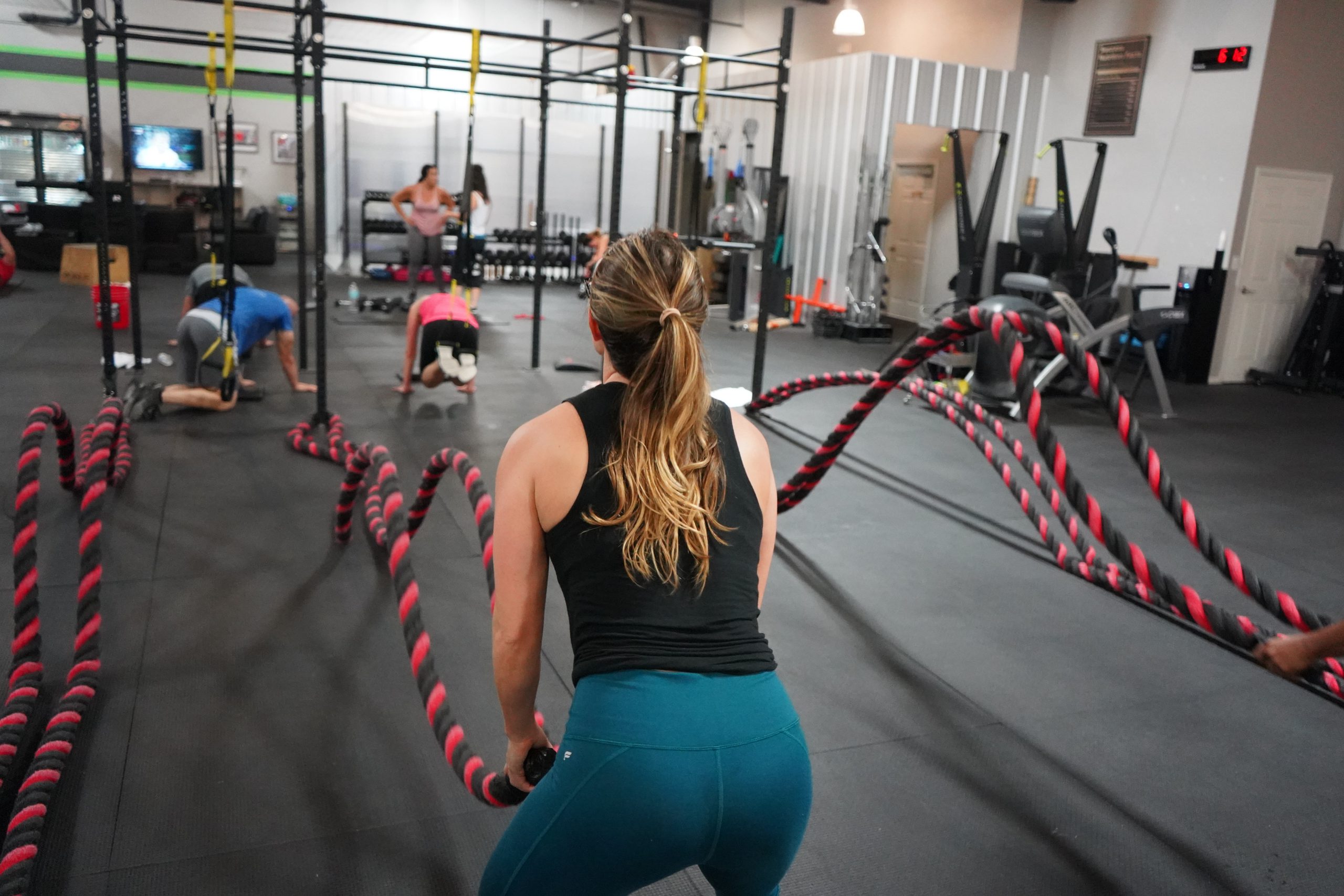 Best Fitness Gear - 
Girl in the gym working out with battle ropes 