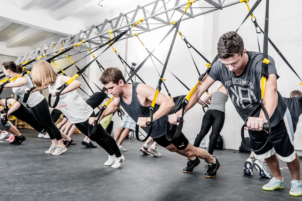 A group of people exercising with TRX straps in the gym