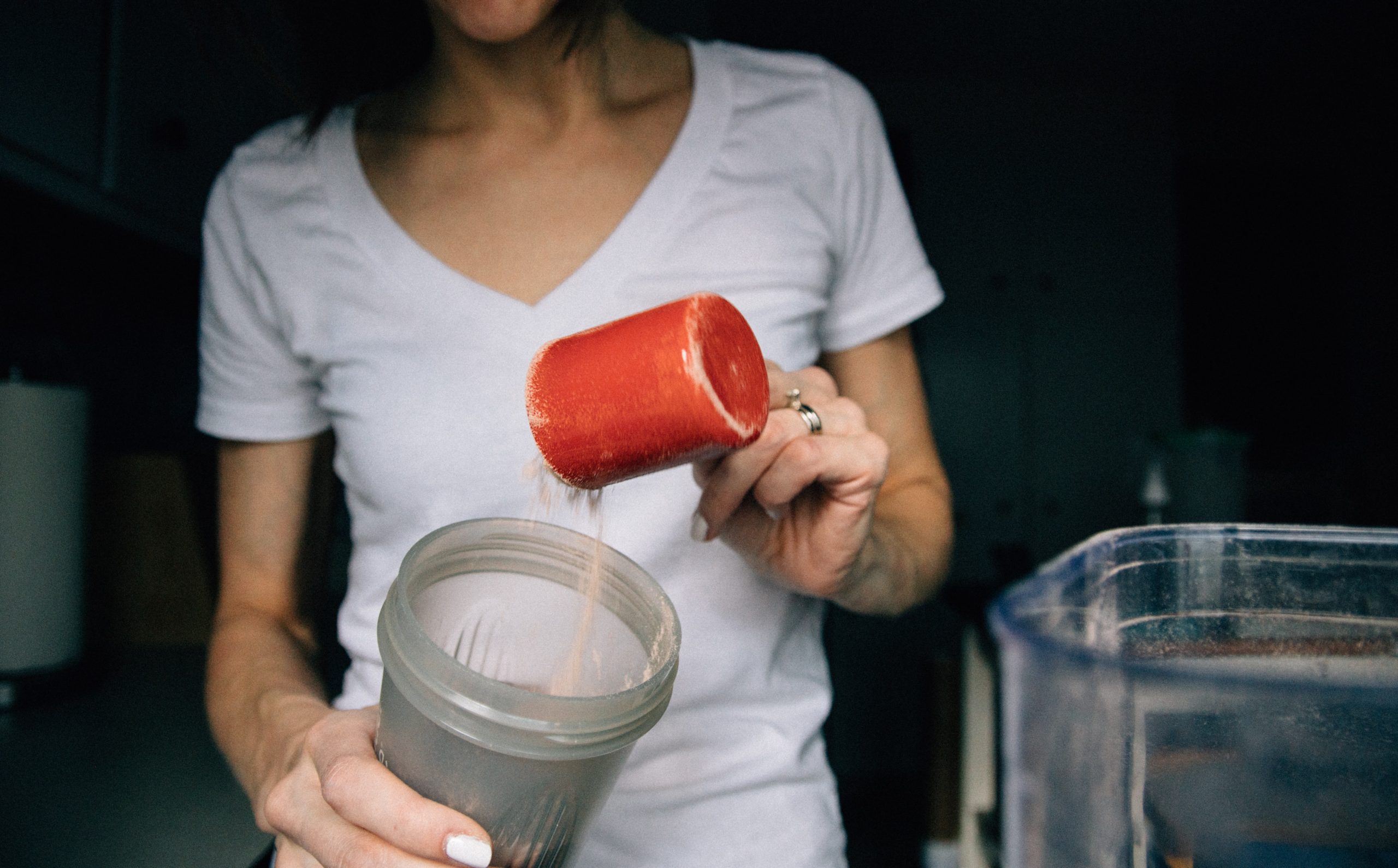 Woman preparing a protein shake using protein powder