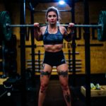 Woman with a barbell on her shoulders getting ready for a squat exercise