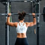 Sixpack Saturday post - A long-haired female weightlifter lifting a heavy barbell over her head